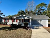 Newly renovated single story home with gray siding, red shutters, and landscaped yard at 11440 Sw 85Th Ave, Ocala, FL 34481