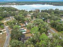 Aerial view showing home on a lake with surrounding houses and trees at 1910 Se 170Th Avenue Rd, Silver Springs, FL 34488