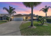 Charming single-story home with a two-car garage and landscaped lawn at 1982 Somerset Ave, The Villages, FL 32162