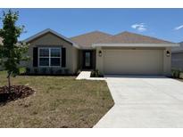 Charming one-story home with a two-car garage, manicured lawn, and a traditional architectural style at 2158 Nw 23Rd Loop, Ocala, FL 34475