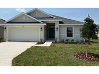 Charming single-Gathering home featuring a two-car garage, a well-maintained lawn, and a covered front entryway at 2162 Nw 23Rd Loop, Ocala, FL 34475