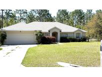 Charming single-story home featuring an attached two-car garage and a well-manicured front lawn at 21962 Sw Nautilus Blvd, Dunnellon, FL 34431