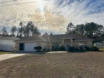 Single-story house with a garage and a well-maintained lawn at 5242 Sw 162Nd Place Rd, Ocala, FL 34473