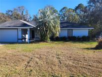 Single-story home with attached garage and mature landscaping at 6 Hickory Loop Way, Ocala, FL 34472