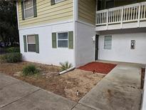 Condo building exterior with green and white paint, landscaping, and walkway at 8241 Fairways Cir # E102, Ocala, FL 34472