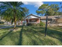 Brick ranch home with covered porch, mature landscaping, and a palm tree at 8671 Sw 97Th St # C, Ocala, FL 34481