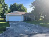 One-story house with attached garage and a spacious yard at 89 Pecan Course Cir, Ocala, FL 34472