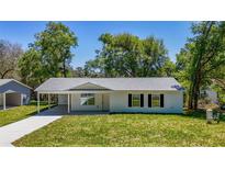 Charming single-story home featuring a covered carport and a freshly landscaped front yard at 16434 Se 57 Pl, Ocklawaha, FL 32179