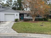 Gray house with white brick accents, attached garage, and well-manicured lawn at 1936 Se 37Th Court Cir, Ocala, FL 34471