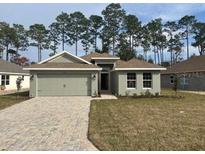 Newly constructed home with a two-car garage and a landscaped front yard at 7661 Sw 180Th Cir, Dunnellon, FL 34432