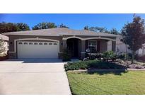 One-story house with landscaped yard, attached garage, and neutral color palette at 7729 Sw 85Th Cir, Ocala, FL 34481