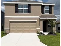 Charming two-story home with a two car garage, black shutters, and manicured lawn at 8699 Sw 44Th Ter, Ocala, FL 34476