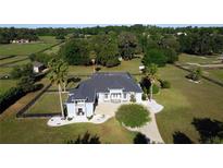 Expansive home with a lush lawn, mature trees and landscaping, and a black fence surrounding the perimeter at 9340 Sw 9Th Ter, Ocala, FL 34476