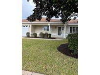 House exterior showcasing a front porch, and a neatly manicured lawn at 13981 Se 86Th Cir, Summerfield, FL 34491