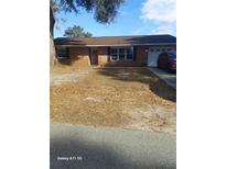 Brick ranch house with attached garage and a large yard at 14525 Se 55Th Ave, Summerfield, FL 34491