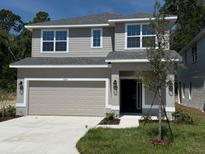 Charming two-story home with a well-maintained lawn and a two car garage on a sunny day at 2210 Nw 23Rd Loop, Ocala, FL 34475