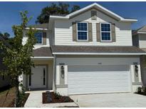Charming two-story home featuring a two-car garage, white siding, and well-maintained landscaping at 2214 Nw 23Rd Loop, Ocala, FL 34475