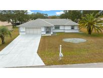 Single-story home with attached garage and landscaped yard at 5894 Sw 102Nd Ln, Ocala, FL 34476