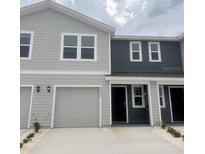 Stylish two-story townhome featuring a one-car garage and modern gray color scheme at 6590 Sw 81St Loop, Ocala, FL 34476