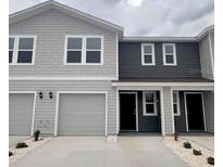 Charming townhouse featuring a blend of gray siding, attached garages, and neatly manicured landscaping at 6594 Sw 81St Loop, Ocala, FL 34476