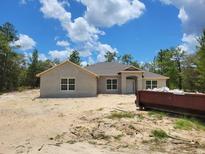 Charming single-story home featuring a stucco exterior, complemented by large windows and a well-manicured lawn at 12238 Sw 85Th Pl, Dunnellon, FL 34432