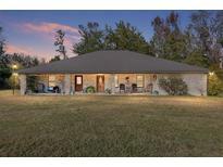 Brick ranch house with a large front porch and expansive lawn at 2821 Se 80Th St, Ocala, FL 34480