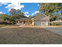 Charming home featuring a two-car garage, front porch, and well-manicured lawn at 6009 Sw 107Th St, Ocala, FL 34476