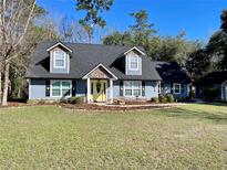 Charming two-story home with a beautifully landscaped front yard and inviting yellow front door at 6701 Se 99Th Pl, Belleview, FL 34420