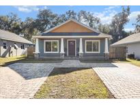 Charming craftsman style home with gray exterior, paver driveway, and front porch at 11759 Bostick St, Dunnellon, FL 34432