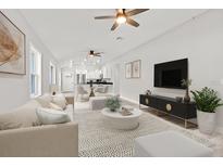 Open concept living area with modern furnishings, a neutral color palette, and hardwood flooring at 11759 Bostick St, Dunnellon, FL 34432
