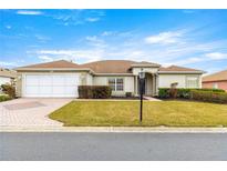 Single-story house with a two-car garage and landscaped lawn at 13957 Se 86Th Cir, Summerfield, FL 34491