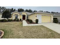 Single-story house with a two-car garage and well-maintained lawn at 16052 Sw 15Th Ct, Ocala, FL 34473