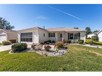 Single-story house with landscaped yard, driveway, and screened porch at 17370 Se 76Th Flintlock Ter, The Villages, FL 32162