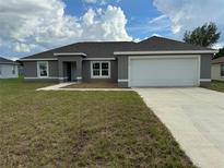 Newly constructed home with gray exterior, two car garage, and grassy lawn at 1776 Sw 161St Pl, Ocala, FL 34473