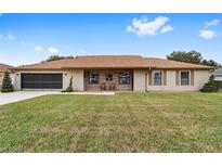 Tan house with brown roof, screened porch, and large yard at 4535 Nw 34Th Pl, Ocala, FL 34482