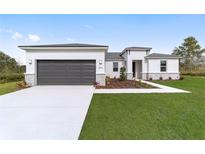 New construction home with a gray garage door and landscaping at 15500 Sw 46Th Cir, Ocala, FL 34473