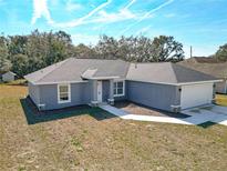 Newly constructed home with gray exterior, a two-car garage, and landscaping at 201 Locust Rd, Ocala, FL 34472