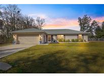 House exterior features a neutral color scheme, well-manicured lawn, and attached garage at 24 Pine Course Pl, Ocala, FL 34472