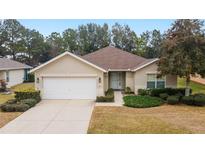 Single-story home with attached garage, landscaping, and a paved driveway at 5409 Sw 42Nd Pl, Ocala, FL 34474