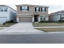 Two-story house with a neutral color palette, stone accents, and a two-car garage at 5429 Sw 44Th Court Rd, Ocala, FL 34474