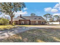 Brick ranch home with a large yard and driveway at 700 Se 49Th Ave, Ocala, FL 34471