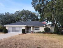 Single-story home with a grey roof and American flag at 7375 Sw 106Th St, Ocala, FL 34476