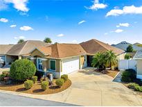 Single-story home with a two-car garage and landscaped front yard at 2997 Teasdale Ter, The Villages, FL 32163