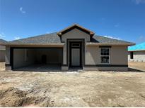 New construction home featuring an open garage, neutral colors, and craftsman-style design under a clear blue sky at 3168 Ne 46Th Ave, Ocala, FL 34470