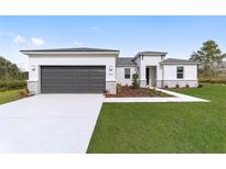 New construction home with modern exterior, two-car garage, and landscaped lawn at 5789 Sw 129Th Place Rd, Ocala, FL 34473
