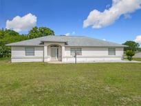 Charming single-story home with a well-maintained lawn and neutral color palette at 8574 Sw 60Th Ct, Ocala, FL 34476