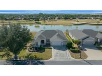 Single-story home with a lake view and golf course background at 9475 Sw 71St Loop, Ocala, FL 34481