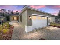 Charming home featuring a well-lit exterior, a spacious driveway, and a welcoming walkway at 10322 Sw 99Th Ln, Ocala, FL 34481