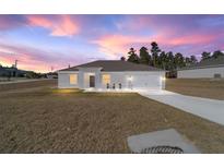 Single-story home with gray roof and white exterior at sunset at 9780 Sw 42Nd Ave, Ocala, FL 34476