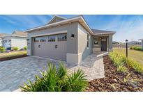 Single-story house with a two-car garage and a paved driveway at 10277 Sw 96Th Loop, Ocala, FL 34481